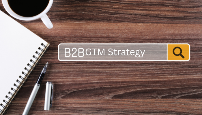 B2B GTM Strategy search bar on a desk with notebook, pen, and coffee