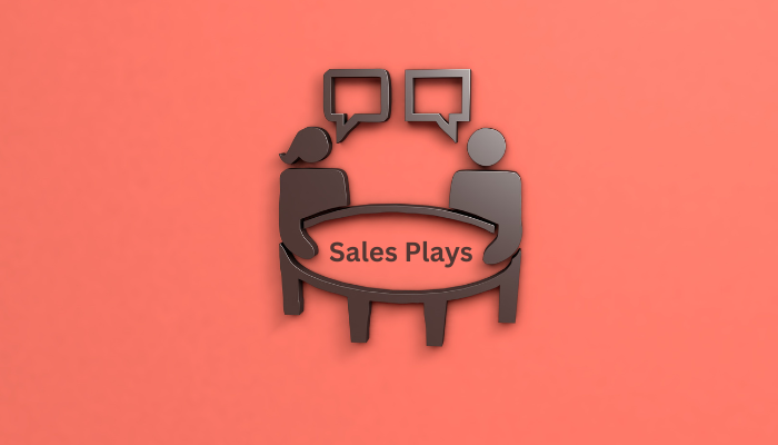 Two people discussing sales plays across a table